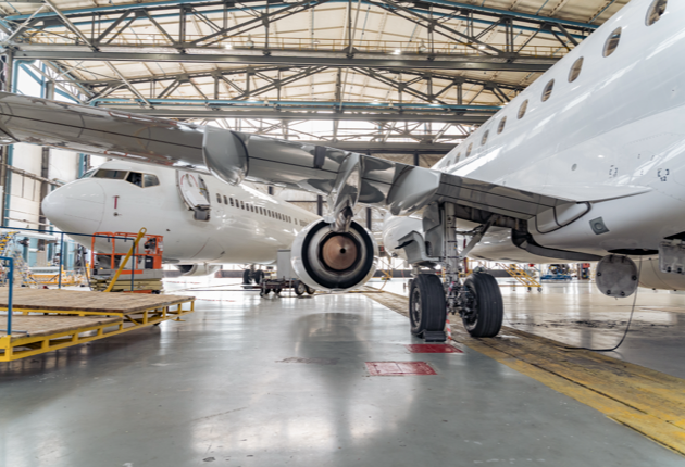 Inside an aircraft hangar with two planes.